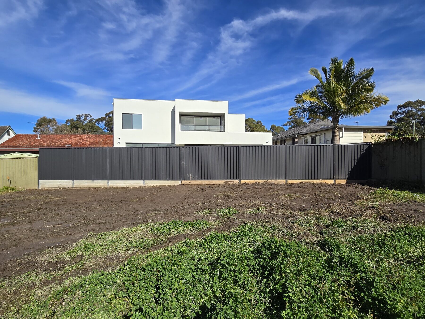 Completed concrete sleeper retaining wall and Colorbond fence